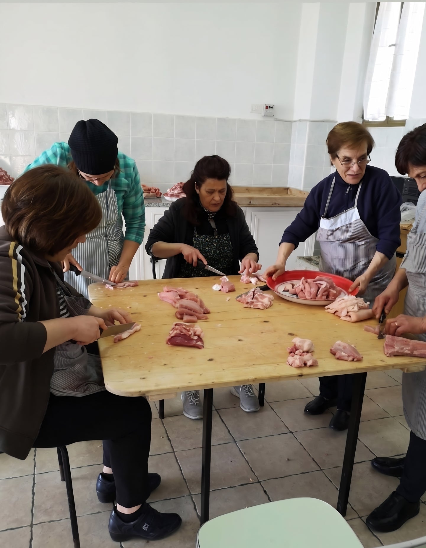donne lucane alle prese con la preparazione della carne lavorandola a punta di coltello come vuole la tradizione 