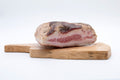 Trancio di guanciale artigianale di Cirigliano da 500g di Sapori Mediterranei su tagliere, con strati di grasso bianco e magro rosa. Selezionato da Borgo Calvera.