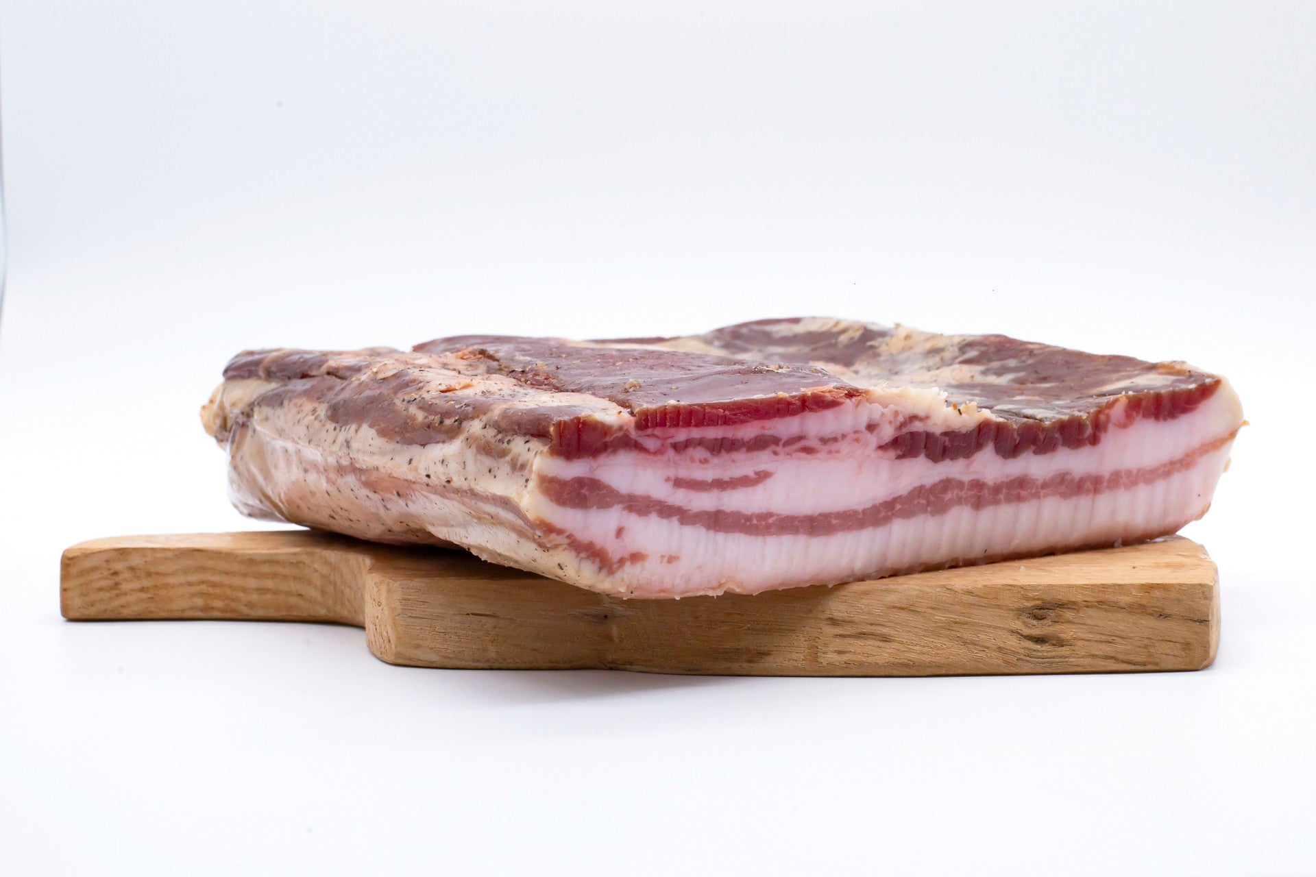 Trancio di Pancetta Tesa artigianale di Cirigliano da 500g (Sapori Mediterranei) con strati alternati rosso vivo e bianco, selezionato da Borgo Calvera.