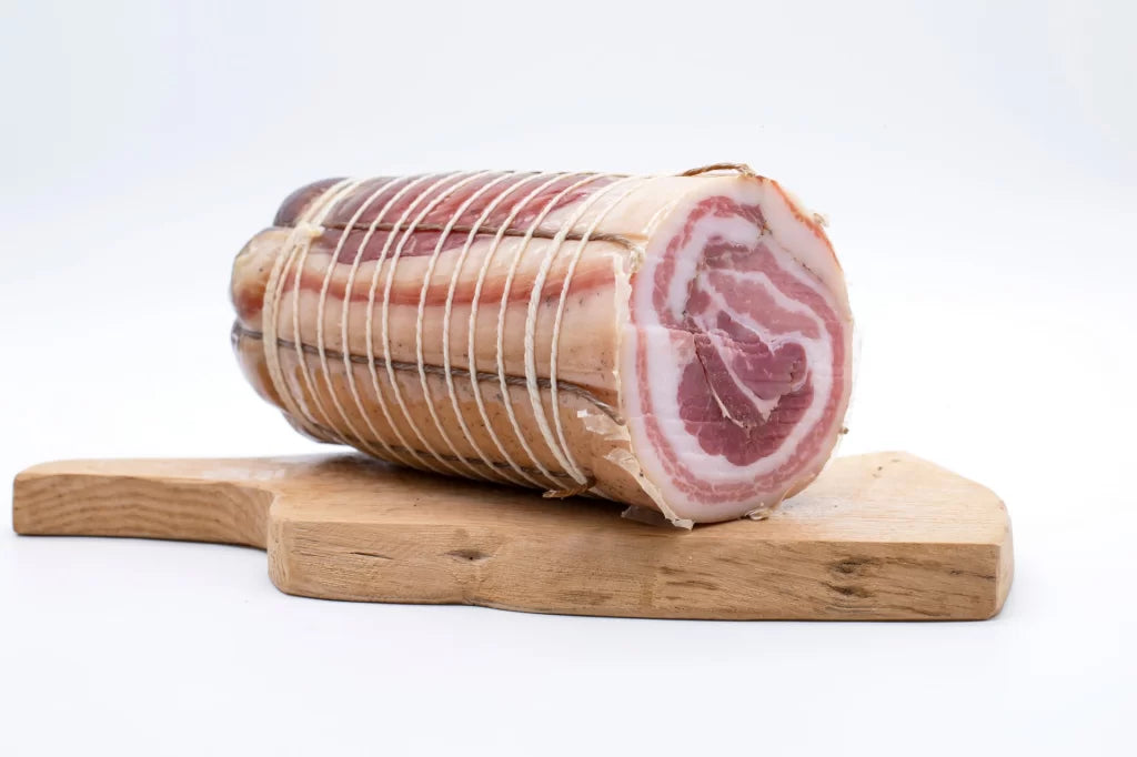 Trancio cilindrico di Pancetta Arrotolata di Cirigliano da 500g (Sapori Mediterranei) con fette a spirale rosse e bianche, selezionata da Borgo Calvera.